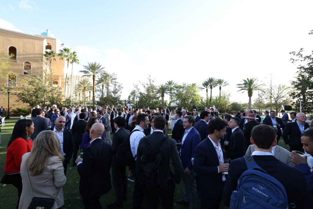 a crowd of people outside with palm trees